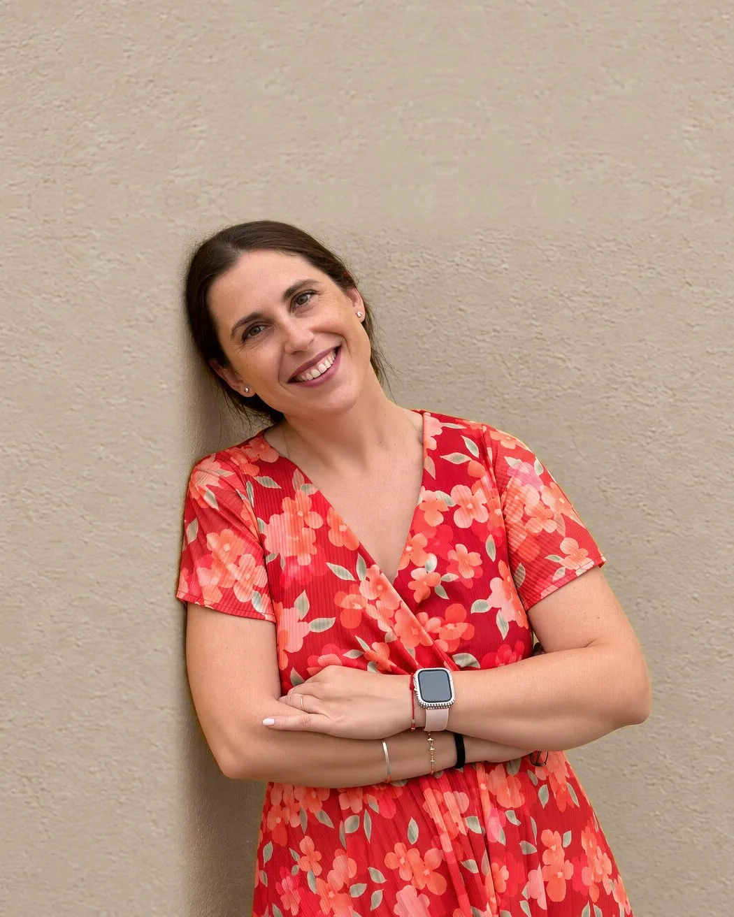 Andrea Arcusa apoyada en una pared, sonriendo